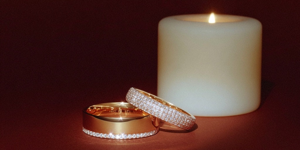 mens diamond edge ring and ladies 4 row pave ring next to candle
