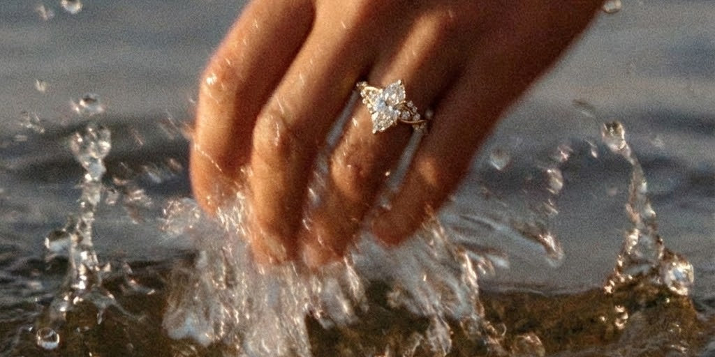 ariel engagement ring on hand splashing ocean water