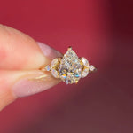 2.01ct F-VVS2 Pear Lab Diamond Sarah. The Sarah features a tapered high polish comfort fit band with a trio of diamonds. The trio features two marquises and one round diamond. The baskets are all lifted to fit a straight band flush against the body.