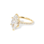 The Alice Marquise lab diamond engagement ring at Princess Bride Diamonds in Huntington Beach, California features a classic pavé diamond band with a cathedral-style setting for a higher, elegant look. It also includes a hidden under-halo beneath the center stone and a diamond bridge for added sparkle from every angle. 14k yellow gold 
