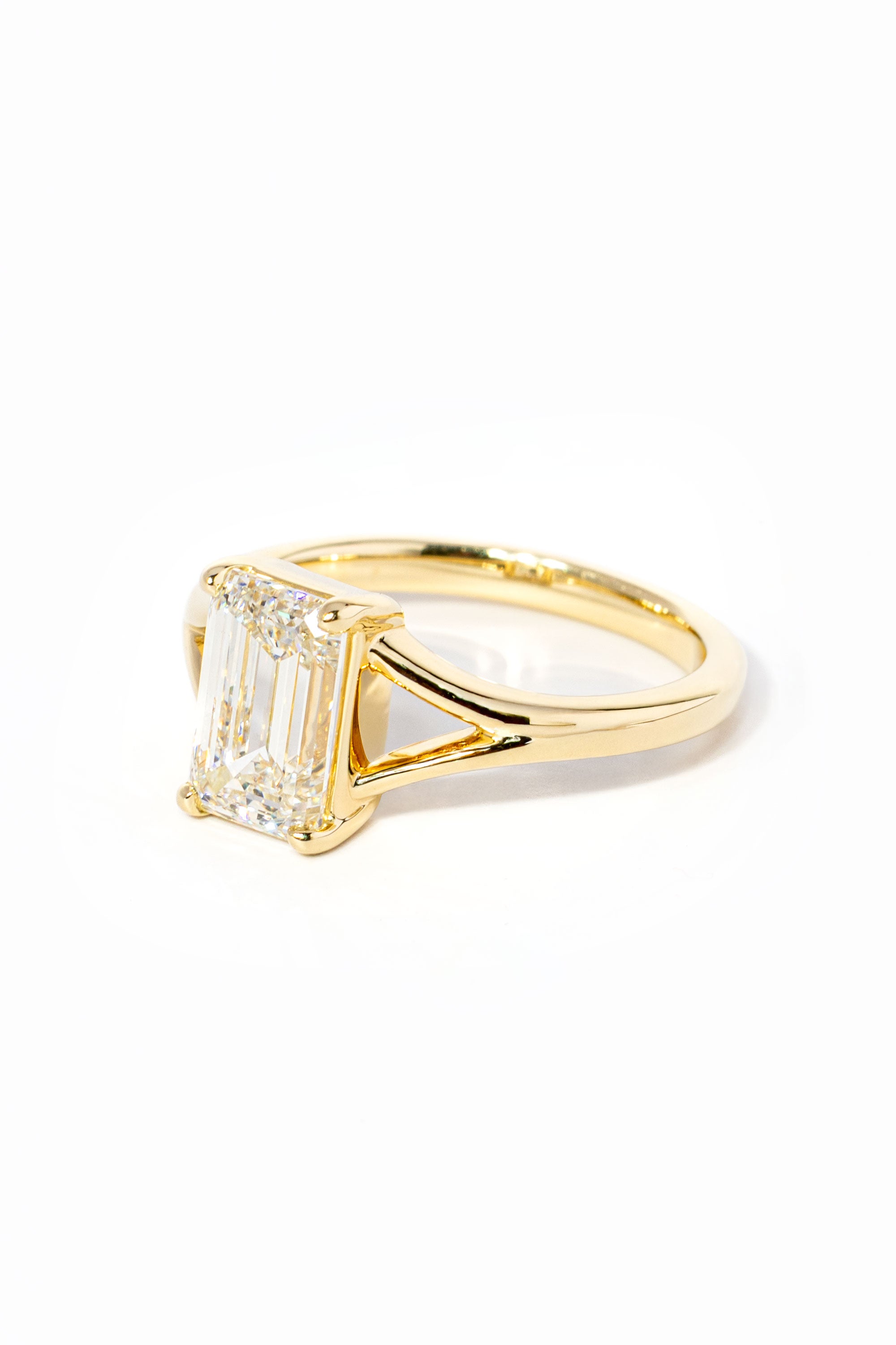 emerald cut diamond on split shank yellow gold ring