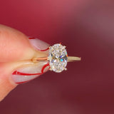 Oval solitaire with hidden halo and diamond bridge in yellow gold