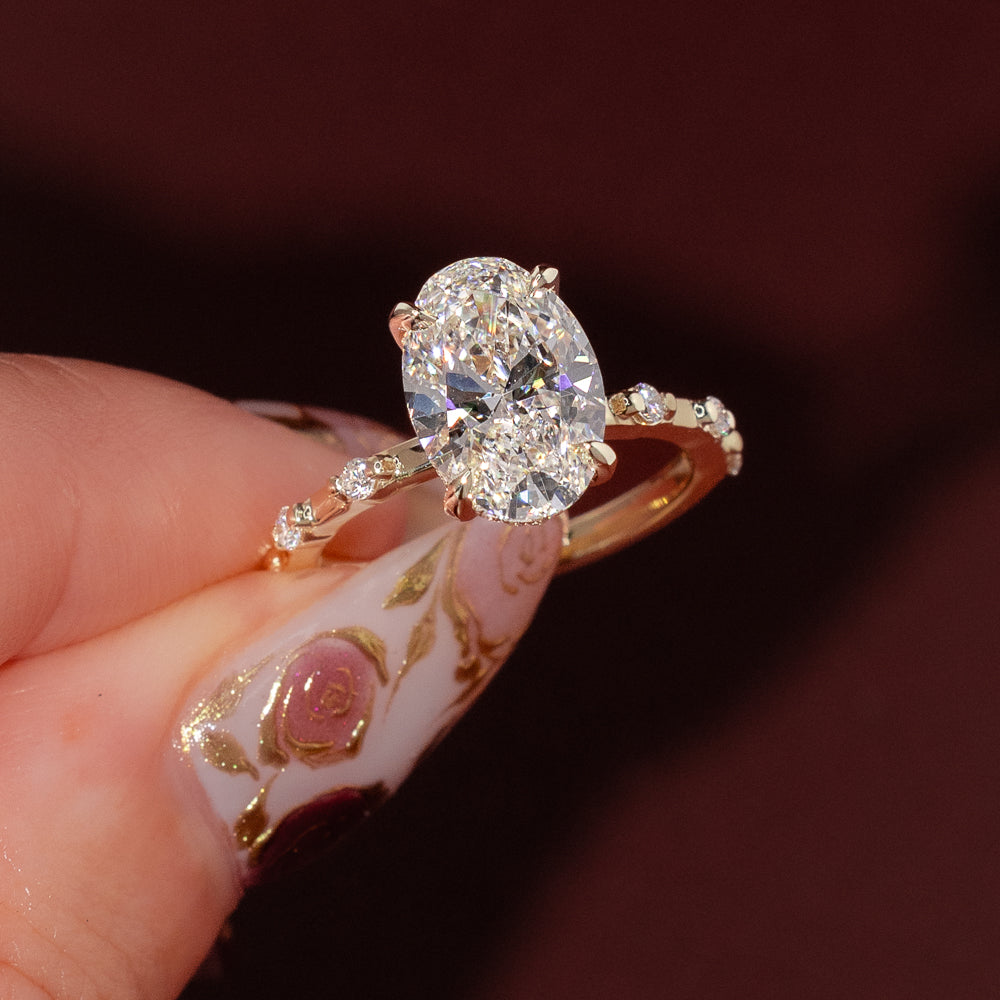 Yellow gold oval engagement ring with hidden halo and spaced diamond band, Daisy design