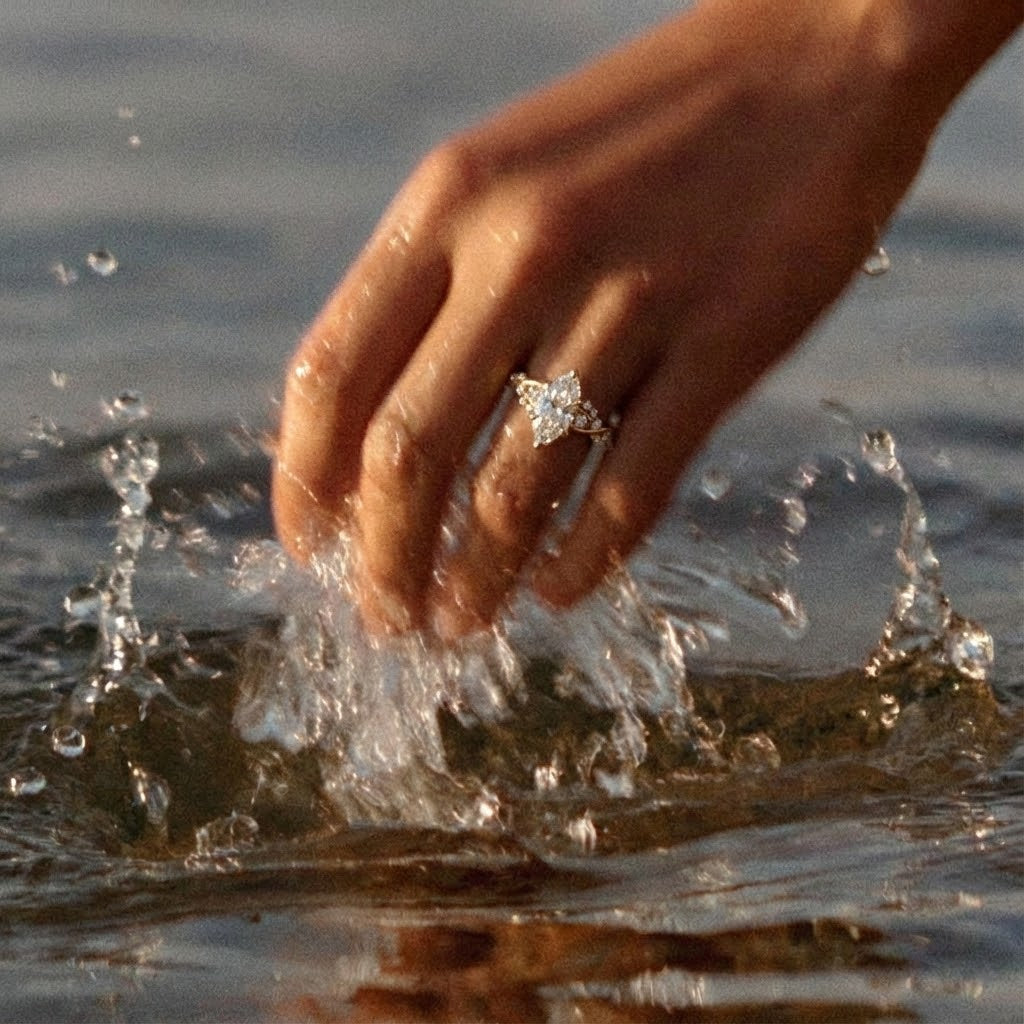 marquise ariel engagement ring on hand in the ocean water