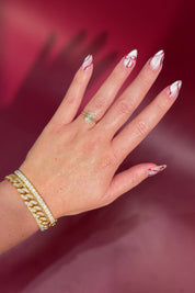 Oval solitaire with hidden halo and diamond bridge in yellow gold