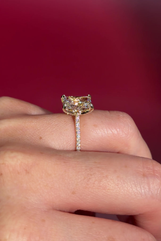 3.07ct F-VVS2 Radiant Lab Diamond Isabela. The Isabela is a cathedral style body with the key features being the pavé diamond lotus petal prongs and diamond bridge. This specific isabela is made with pavé side diamonds and is solid 14k yellow gold.