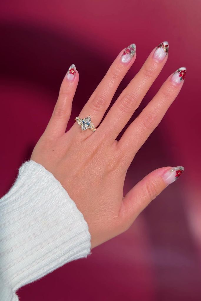 marquise diamond yellow gold engagement ring with alternating side stones on hand