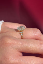 oval lab diamond cluster side stone nature inspired yellow gold engagement ring setting with petal prong basket on hand