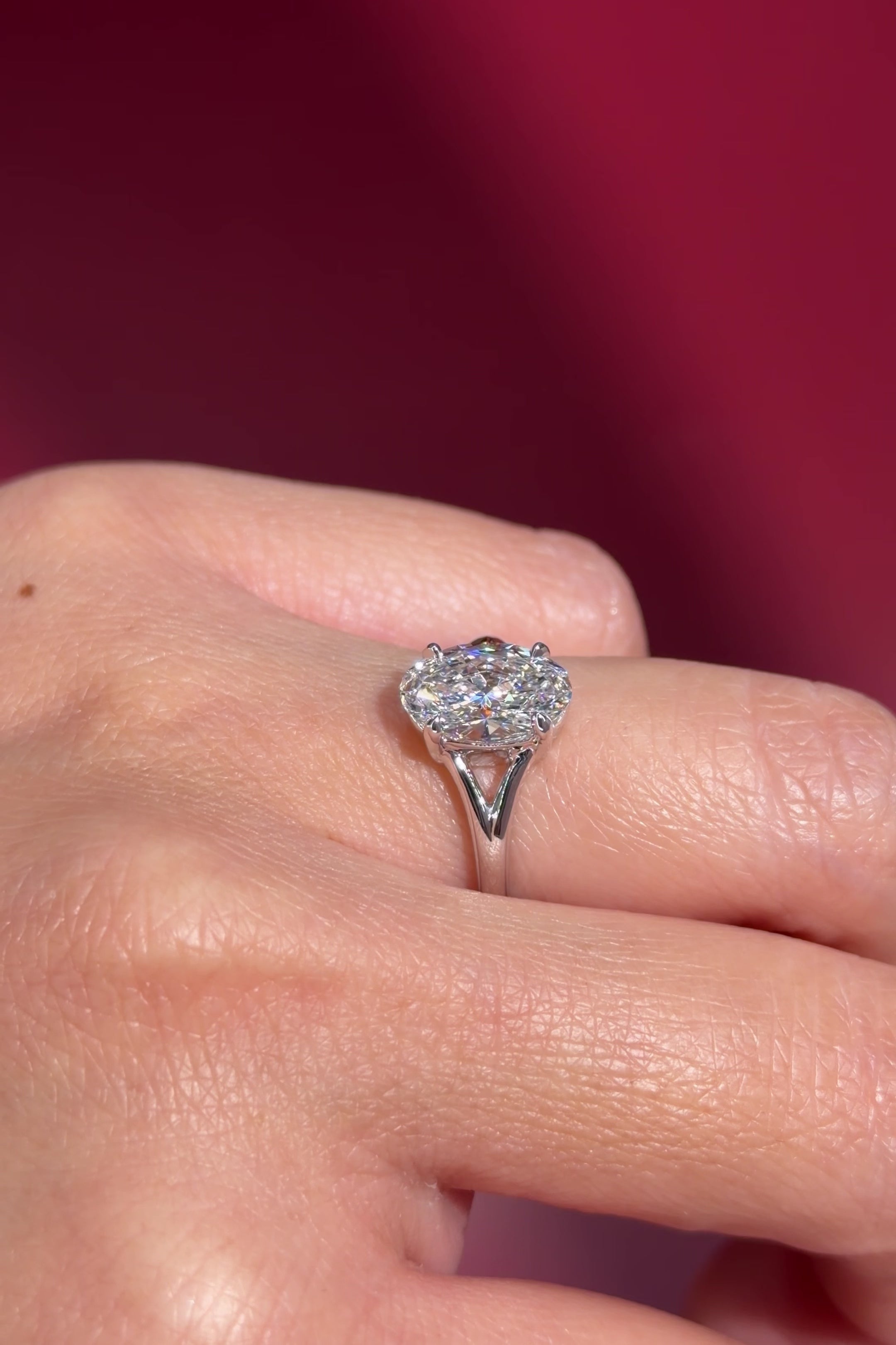 oval lab diamond white gold solitaire split shank engagement ring on hand