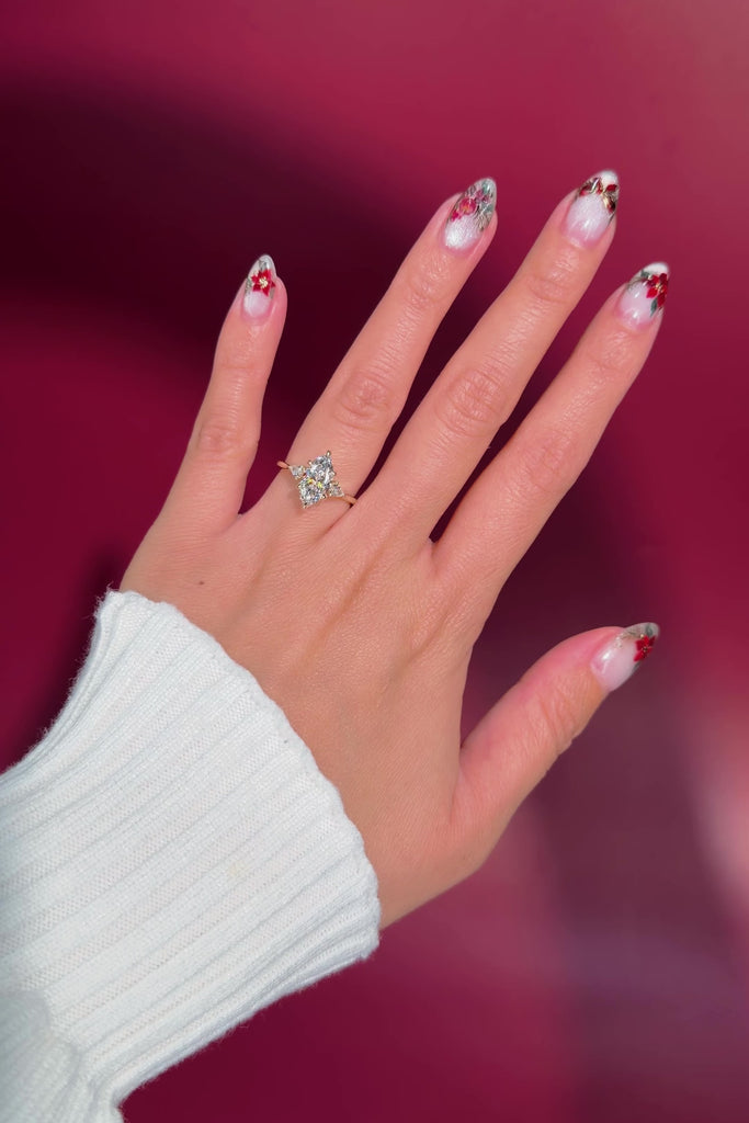 marquise yellow gold engagement ring with pear side stones on hand