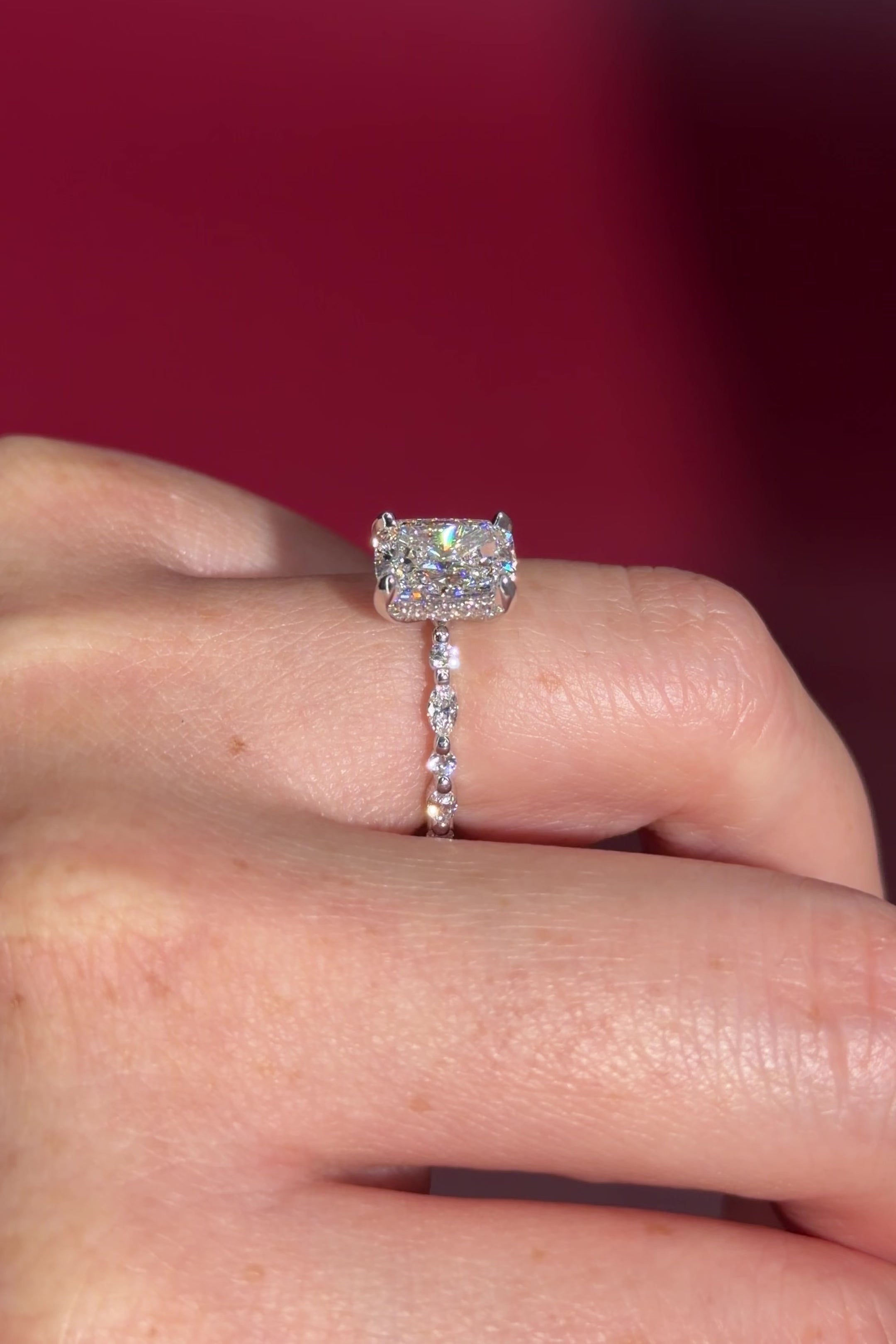 The Rei is a traditional style engagement ring featuring a hidden halo set between the prongs, adding subtle sparkle beneath the center stone.

The standout detail of this design is the floating marquise and round side diamonds, each held by a single prong. This setting allows each side diamond to be fully visible from every angle, creating a light, airy, and elegant look.

Because of this construction, Rei is a more delicate and high maintenance style, best suited for those who are mindful with daily wear 