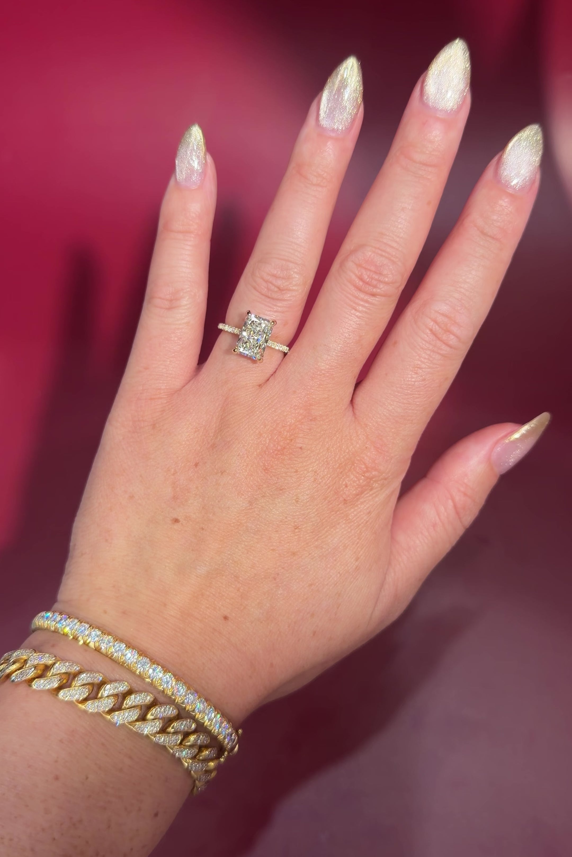 3.07ct F-VVS2 Radiant Lab Diamond Isabela. The Isabela is a cathedral style body with the key features being the pavé diamond lotus petal prongs and diamond bridge. This specific isabela is made with pavé side diamonds and is solid 14k yellow gold.