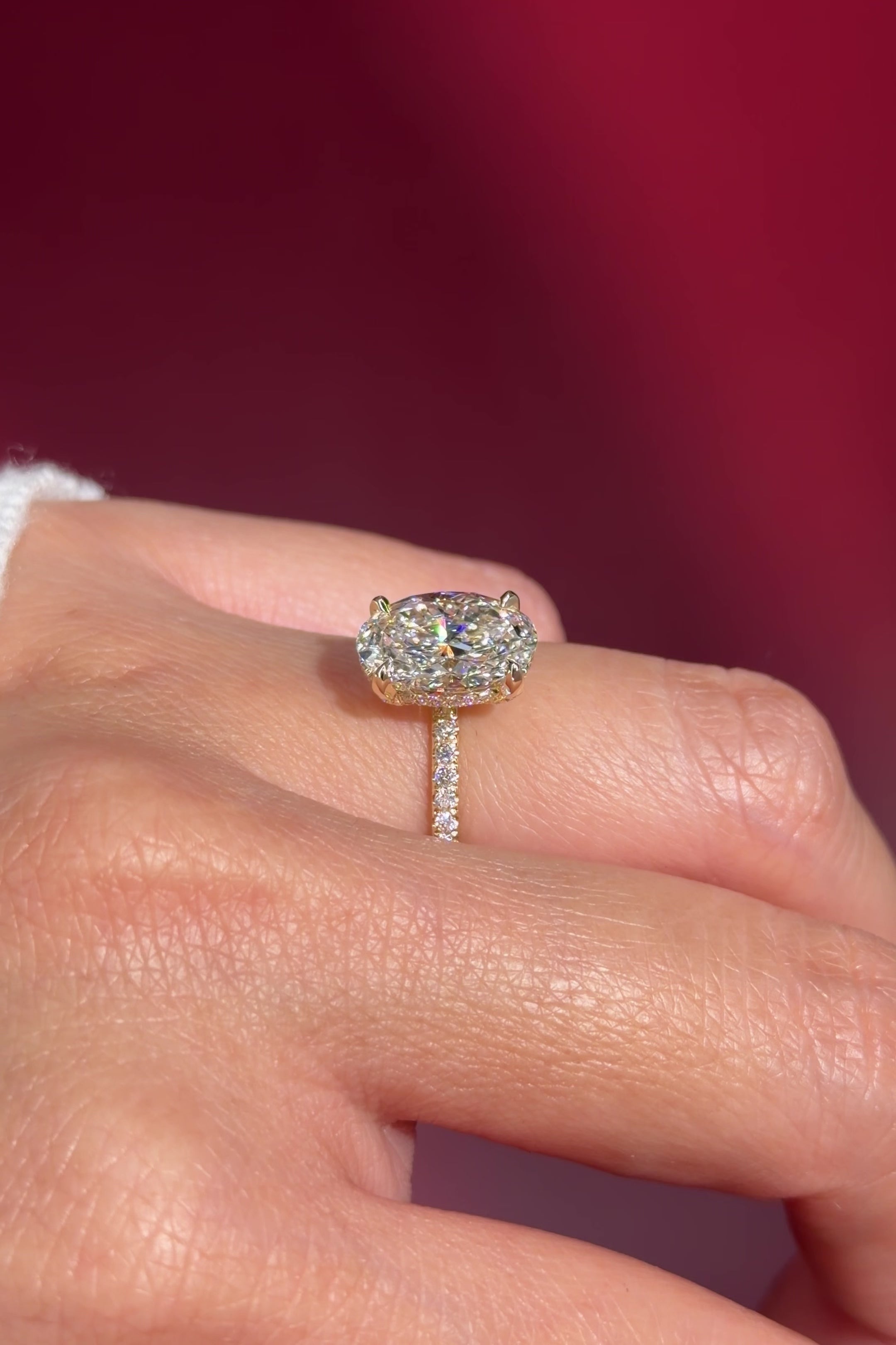 oval lab diamond engagement ring pavé band with diamond prongs and hidden halo on hand