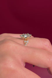 marquise diamond yellow gold engagement ring with alternating side stones on hand