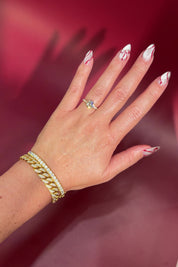 Round Solitaire Engagement Ring with Pavé Side Diamonds in yellow Gold with Petal Prongs on hand