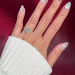 oval lab diamond cluster side stones whimsical yellow gold engagement ring on hand