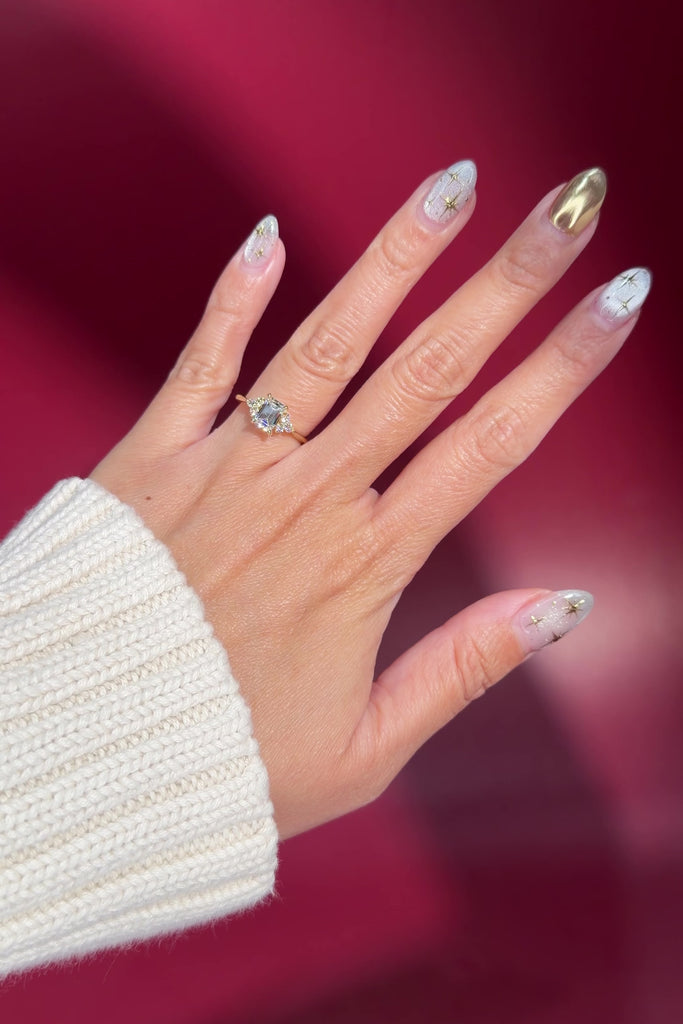 emerald lab diamond engagement ring trio side stone cluster yellow gold on hand