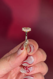 Oval solitaire with hidden halo and diamond bridge in yellow gold