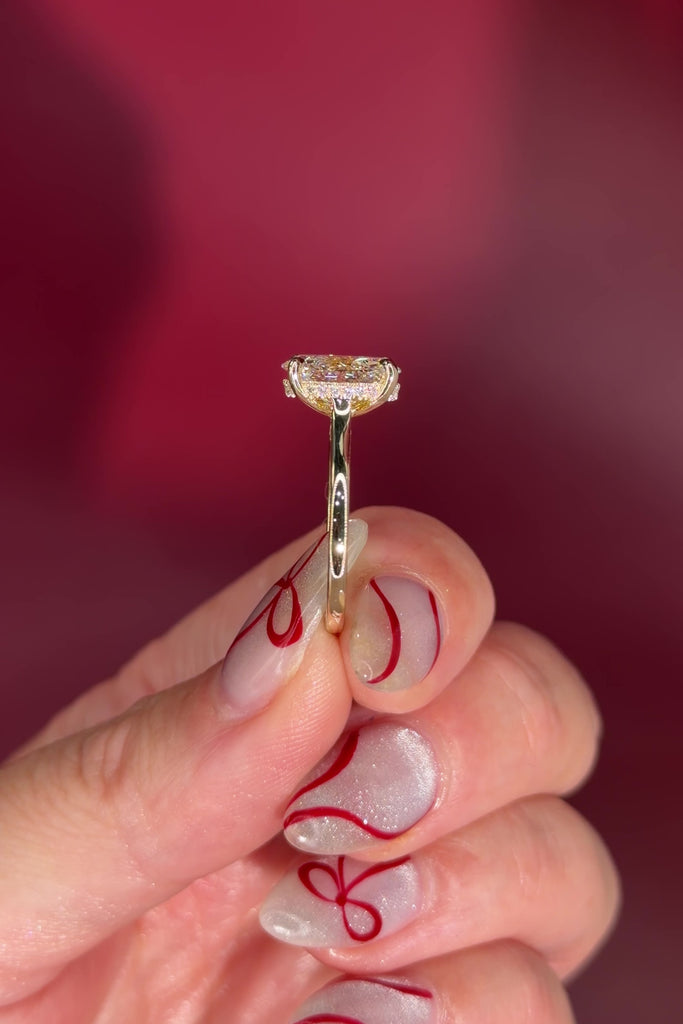 Oval solitaire with hidden halo and diamond bridge in yellow gold