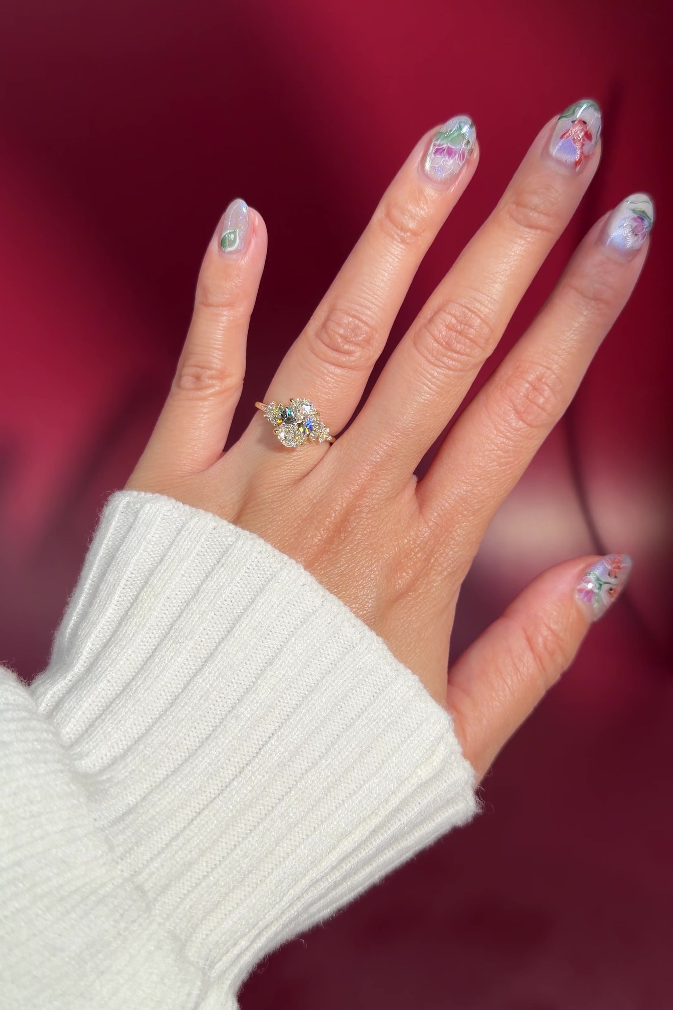 oval lab diamond engagement ring side stone cluster nature inspired yellow gold setting with petal prong basket on hand