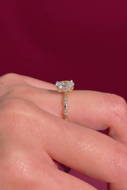 oval floating diamond spaced out band yellow gold engagement ring on hand