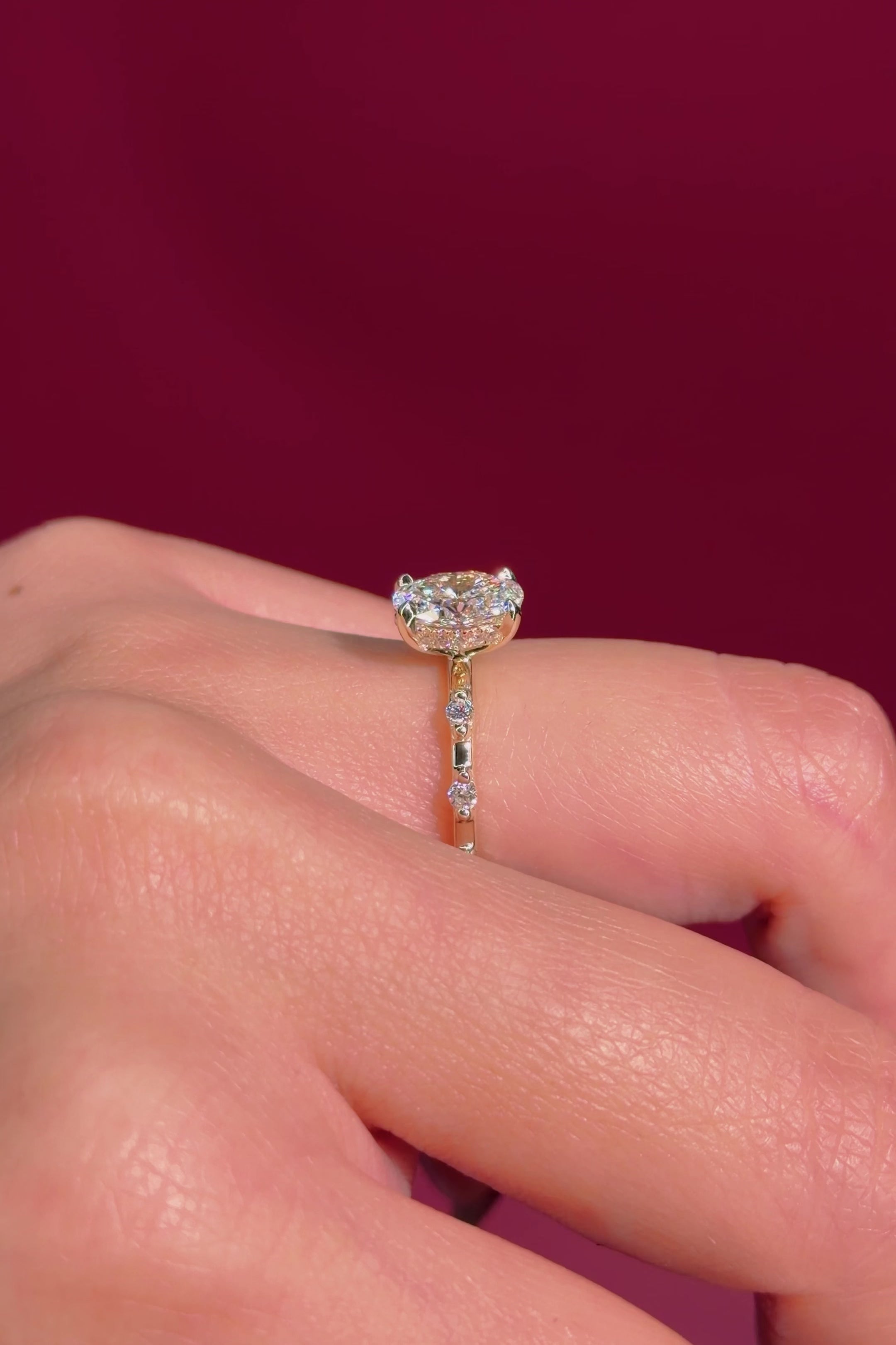 oval floating diamond spaced out band yellow gold engagement ring on hand