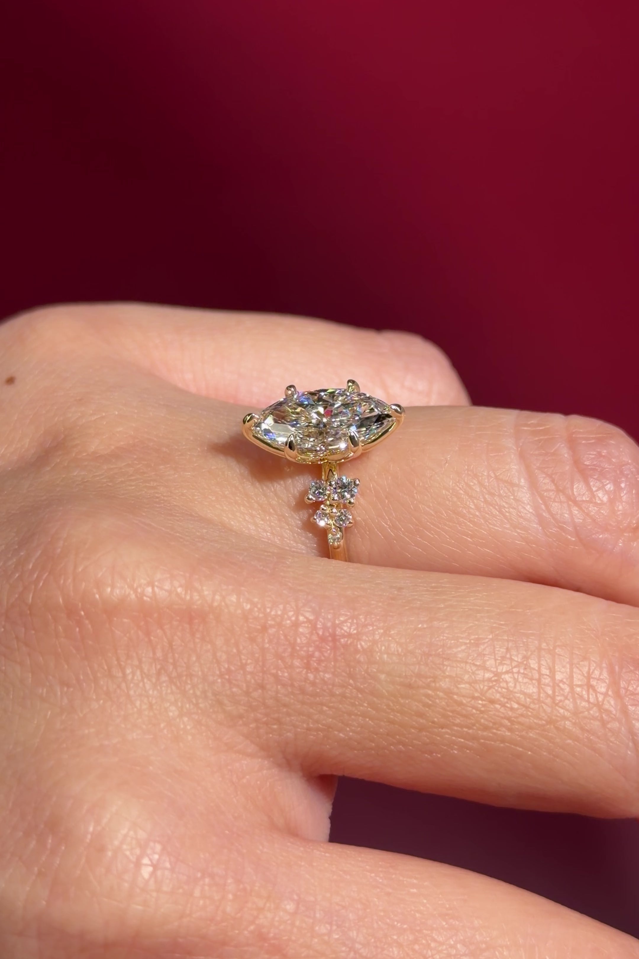 marquise lab diamond cluster side stone nature inspired engagement ring yellow gold setting on hand