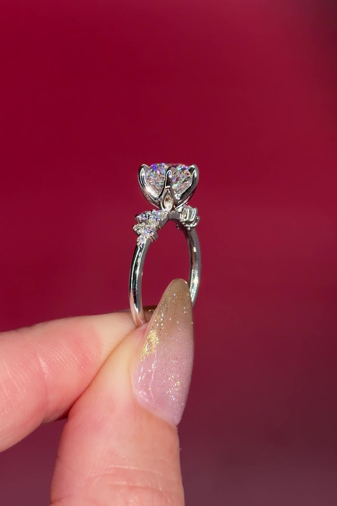 2.00ct D-VVS1 Round Lab Diamond Nova. This is a traditional body engagement ring featuring organic cluster side diamonds that resemble star dust or baby's breath. The center stone is held by our signature petal prongs.