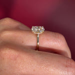 Oval solitaire with hidden halo and diamond bridge in yellow gold