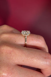 Oval solitaire with hidden halo and diamond bridge in yellow gold