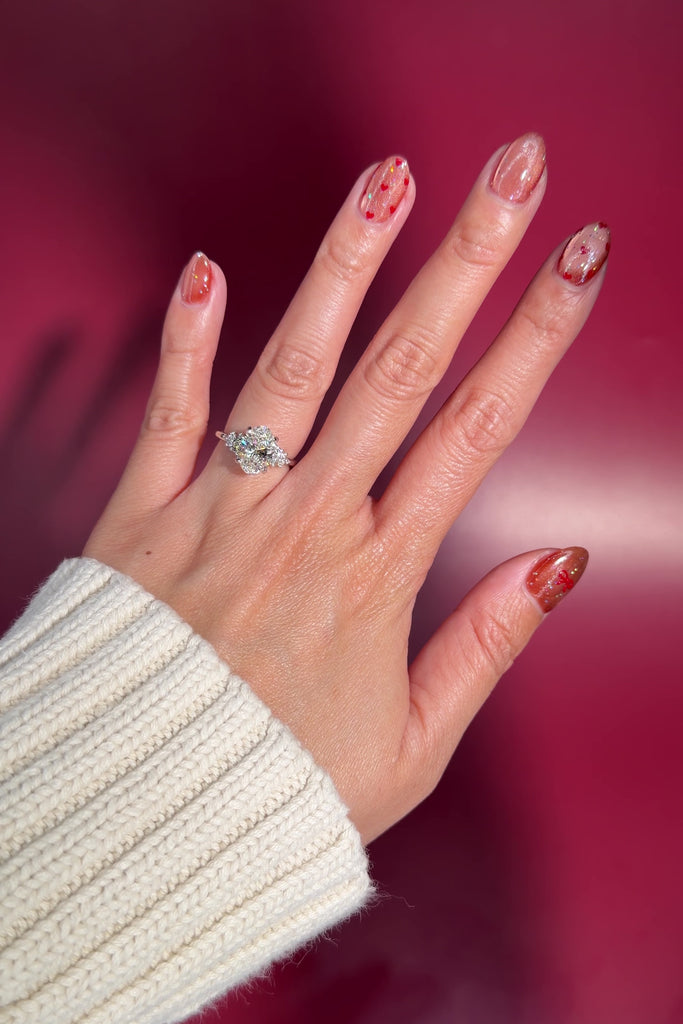 whimsical nature inspired 2.25ct oval lab diamond cluster side stones engagement ring with petal prong basket white gold on hand