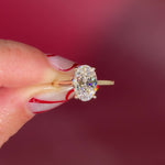 Oval solitaire with hidden halo and diamond bridge in yellow gold