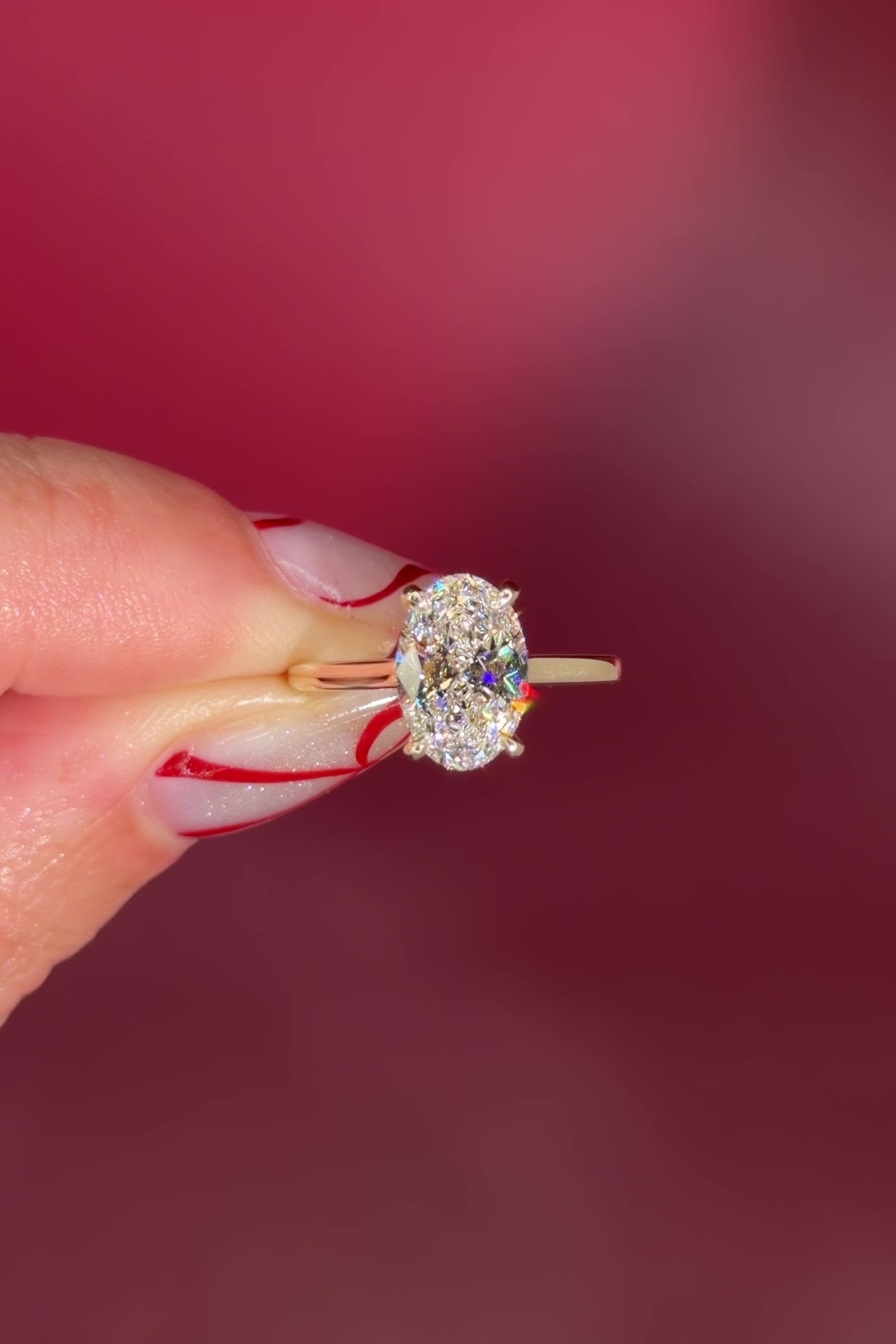 Oval solitaire with hidden halo and diamond bridge in yellow gold