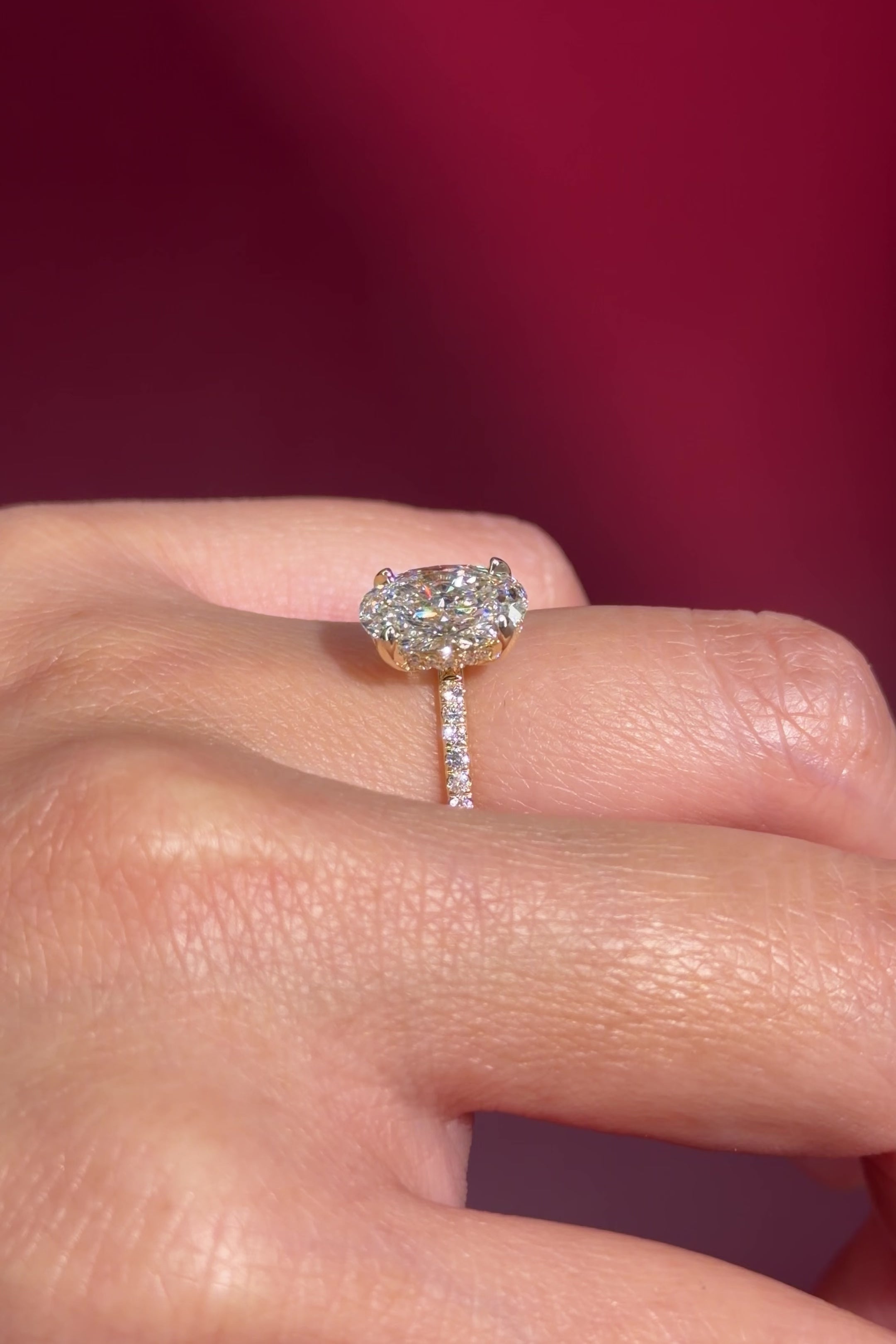 oval lab diamond engagement ring pave band hidden halo yellow gold on hand profile view