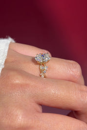 oval lab diamond cluster side stones whimsical yellow gold engagement ring on hand