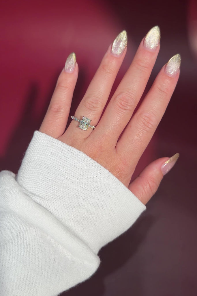 The Rei is a traditional style engagement ring featuring a hidden halo set between the prongs, adding subtle sparkle beneath the center stone.

The standout detail of this design is the floating marquise and round side diamonds, each held by a single prong. This setting allows each side diamond to be fully visible from every angle, creating a light, airy, and elegant look.

Because of this construction, Rei is a more delicate and high maintenance style, best suited for those who are mindful with daily wear 