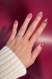 whimsical oval lab diamond engagement ring cluster side stones nature inspired white gold with petal prong basket on hand