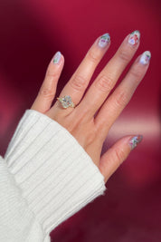 oval lab diamond cluster side stone nature inspired yellow gold engagement ring setting with petal prong basket on hand