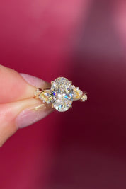 3.04ct E-VVS2 Oval Lab Diamond Ariel. The Ariel engagement ring is inspired by the sea. A unique twist on the classic Nova design, Ariel features a captivating center stone enveloped by wave-like contours. Delicate diamond bubble side stones, reminiscent of ocean bubbles, add a whimsical touch. Crafted precisely, this ring seamlessly blends timeless elegance with an underwater allure.