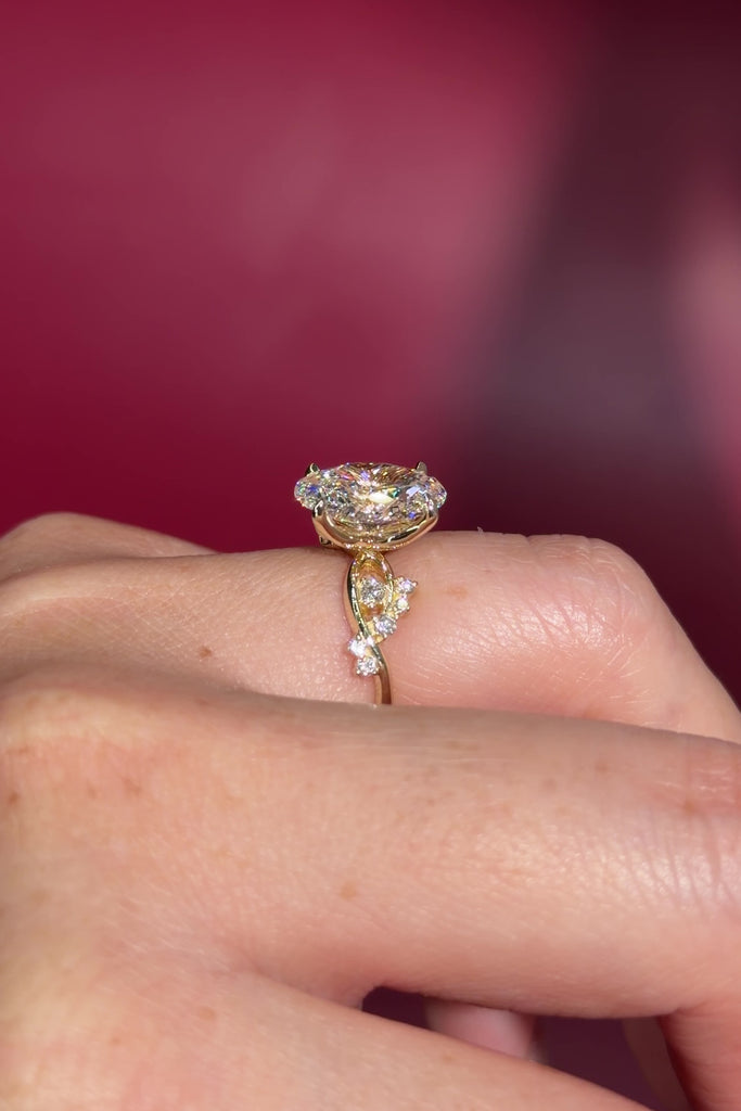 3.04ct E-VVS2 Oval Lab Diamond Ariel. The Ariel engagement ring is inspired by the sea. A unique twist on the classic Nova design, Ariel features a captivating center stone enveloped by wave-like contours. Delicate diamond bubble side stones, reminiscent of ocean bubbles, add a whimsical touch. Crafted precisely, this ring seamlessly blends timeless elegance with an underwater allure.