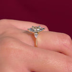 marquise yellow gold engagement ring with pear side stones on hand