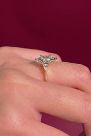 marquise yellow gold engagement ring with pear side stones on hand