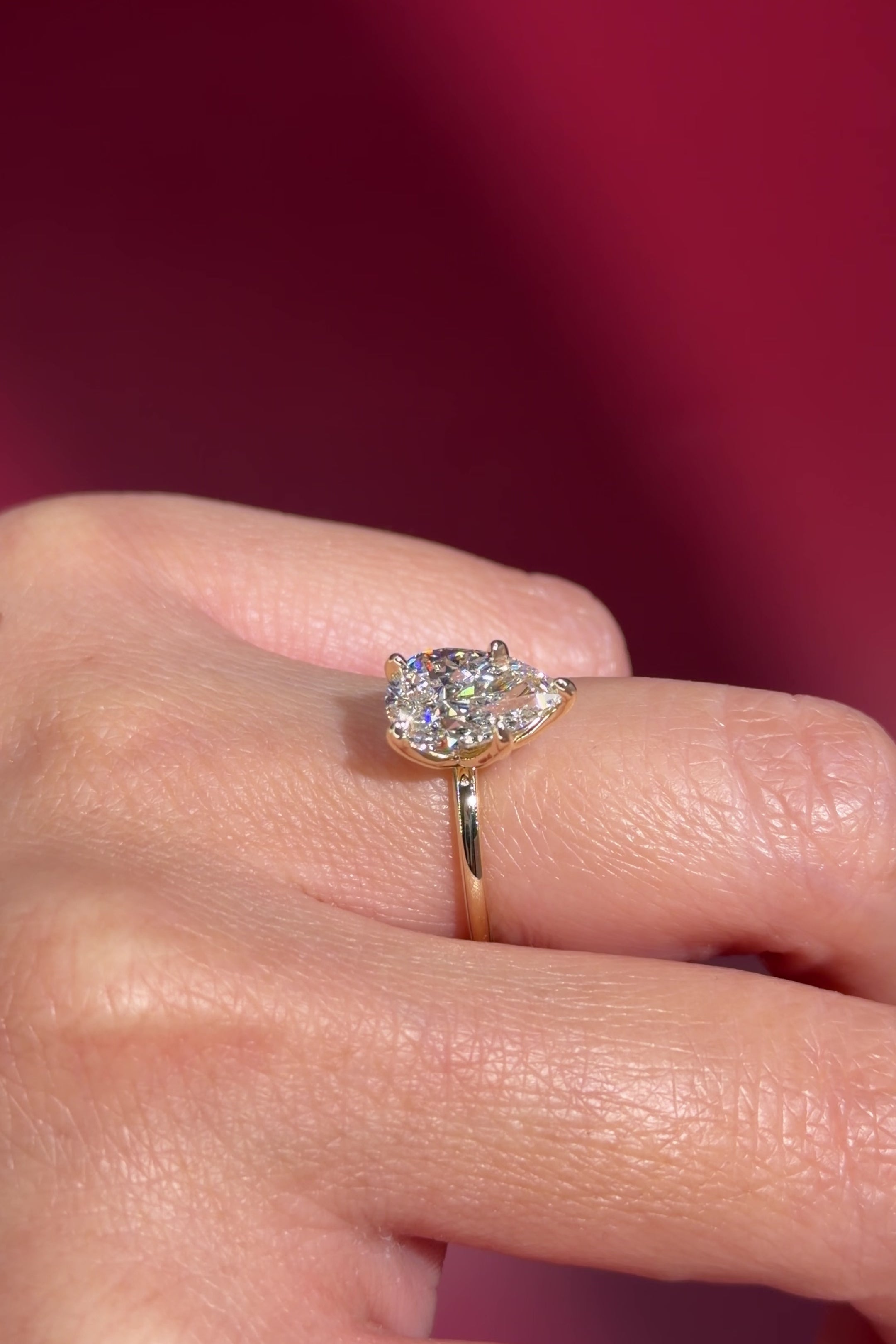 pear lab diamond solitaire engagement ring with flower petal prong basket yellow gold on hand