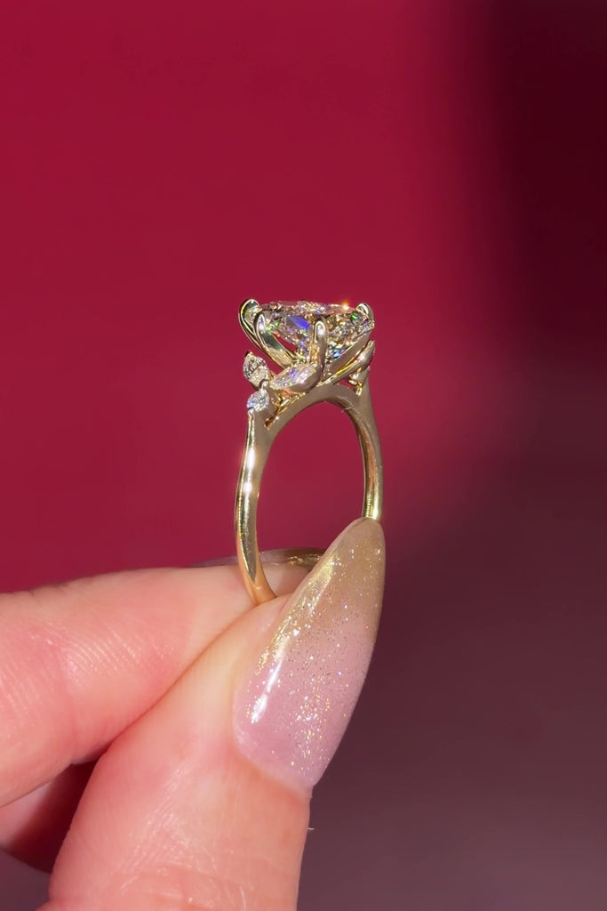 2.01ct F-VVS2 Pear Lab Diamond Sarah. The Sarah features a tapered high polish comfort fit band with a trio of diamonds. The trio features two marquises and one round diamond. The baskets are all lifted to fit a straight band flush against the body.