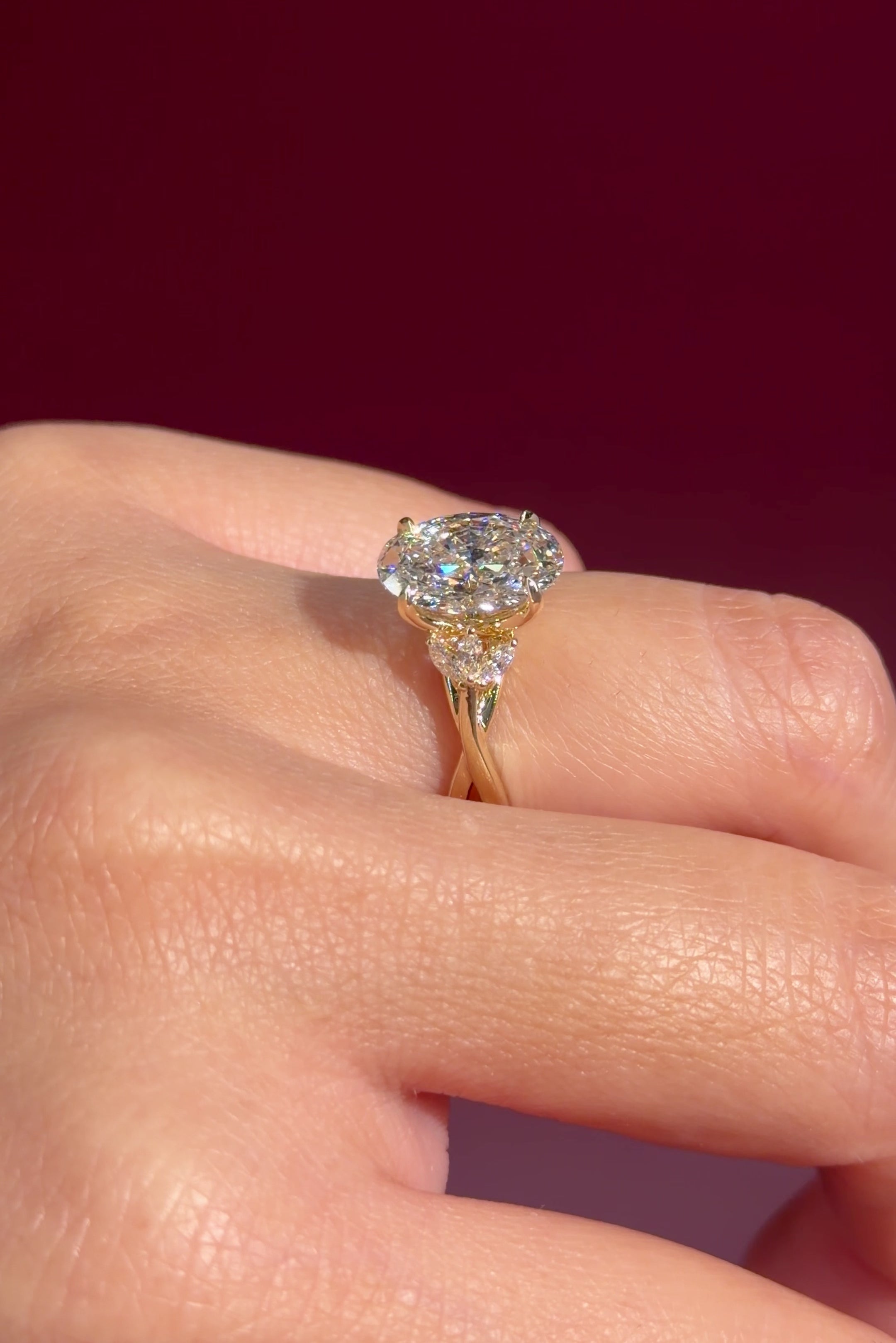 oval lab diamond nature inspired twist band engagement ring yellow gold cluster side stone setting on hand