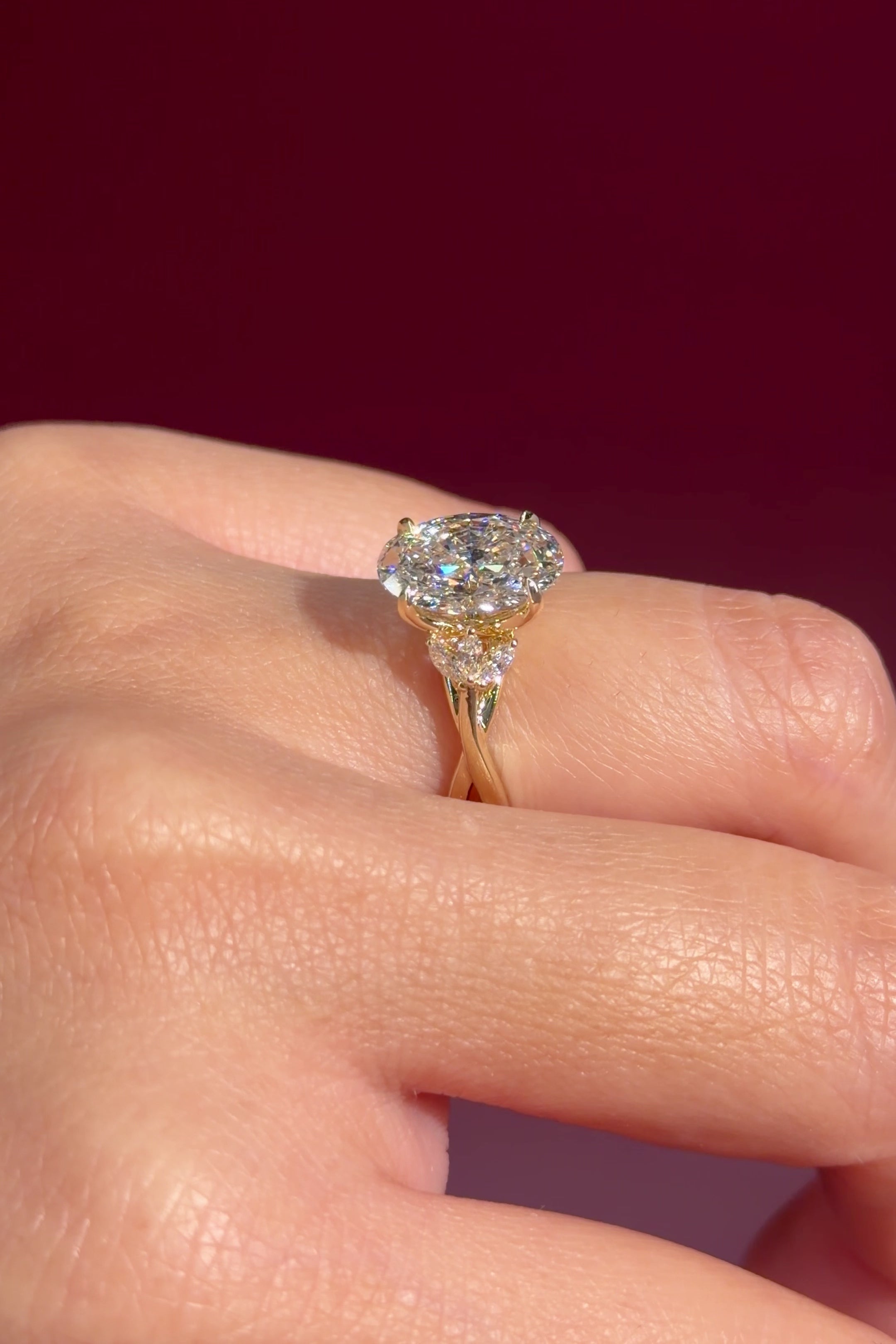 oval lab diamond nature inspired twist band engagement ring yellow gold cluster side stone setting on hand