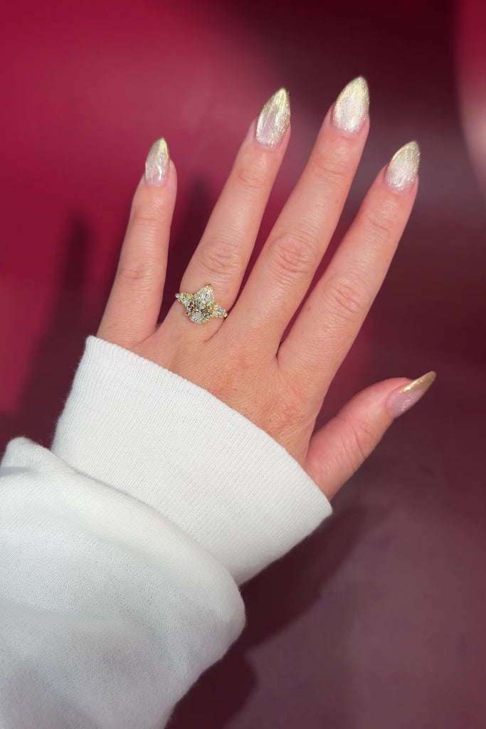 3.03ct D-VVS2 Pear Lab Diamond Brandi.

The Brandi is an inline style engagement ring featuring a symmetrical cluster of side diamonds that create a bold, sculptural look&nbsp;

Because of its inline design, straight wedding bands will not stack flush. This style pairs best with a curved or custom wedding band, or it can be worn beautifully on its own without a wedding band at all&nbsp;

A striking choice for those who love a statement engagement ring with intentional design details.