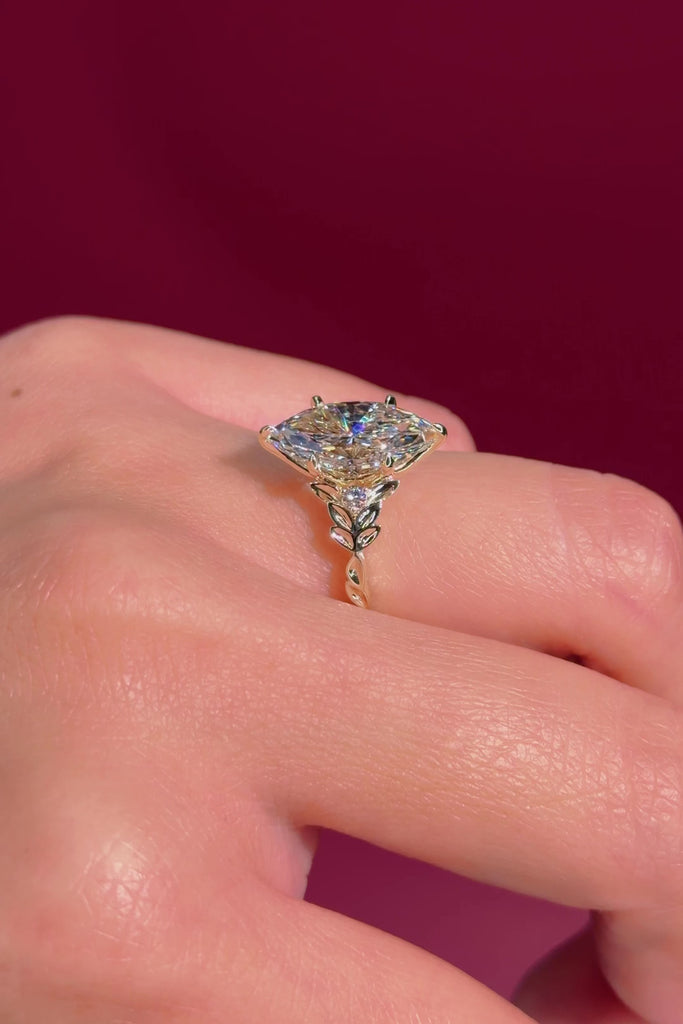 marquise diamond leafy nature inspired yellow gold engagement ring on hand