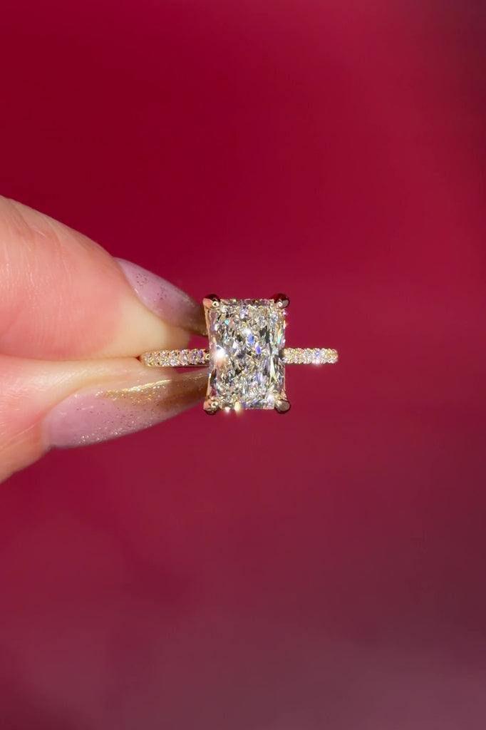 3.07ct F-VVS2 Radiant Lab Diamond Isabela. The Isabela is a cathedral style body with the key features being the pavé diamond lotus petal prongs and diamond bridge. This specific isabela is made with pavé side diamonds and is solid 14k yellow gold.